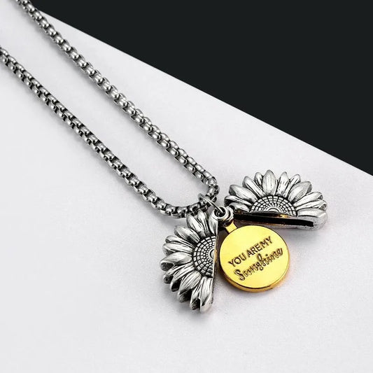 Halsband med silverpläterad solrosdesign som öppnas för att visa meddelandet "You are my sunshine", med en robust kedja och detaljerad blomma.